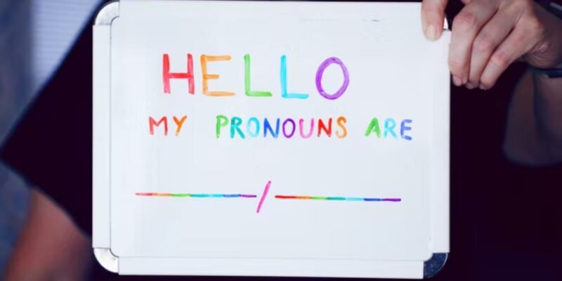 Person holding pronoun sign