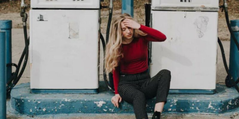 Girl sitting at gas pumps