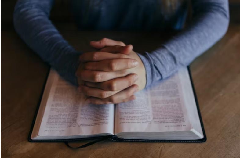 Praying hands on bible