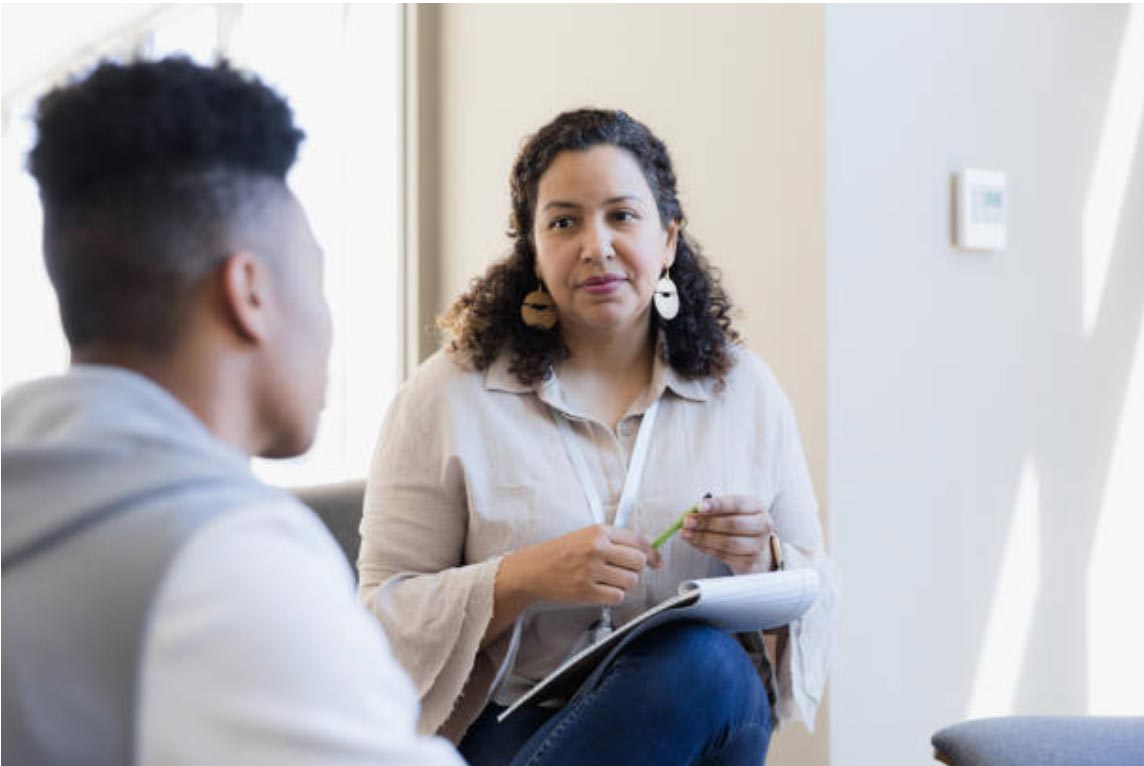 WOMAN CHRISTIAN COUNSELOR TALKING WITH YOUNG MAN