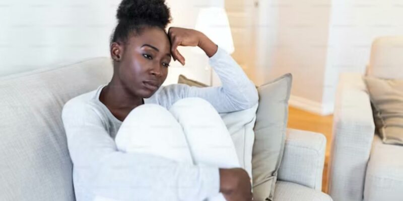 African Woman on sofa thinking.